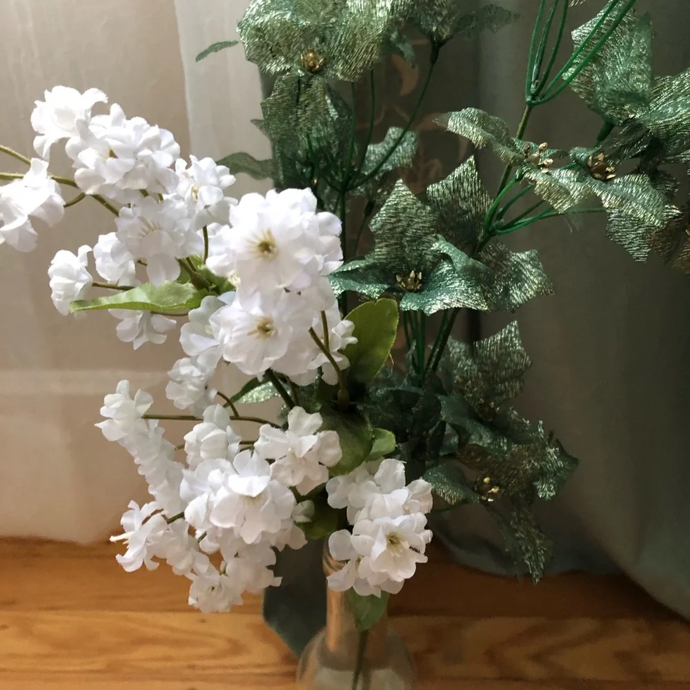 Faux floral with leaves in wine bottle